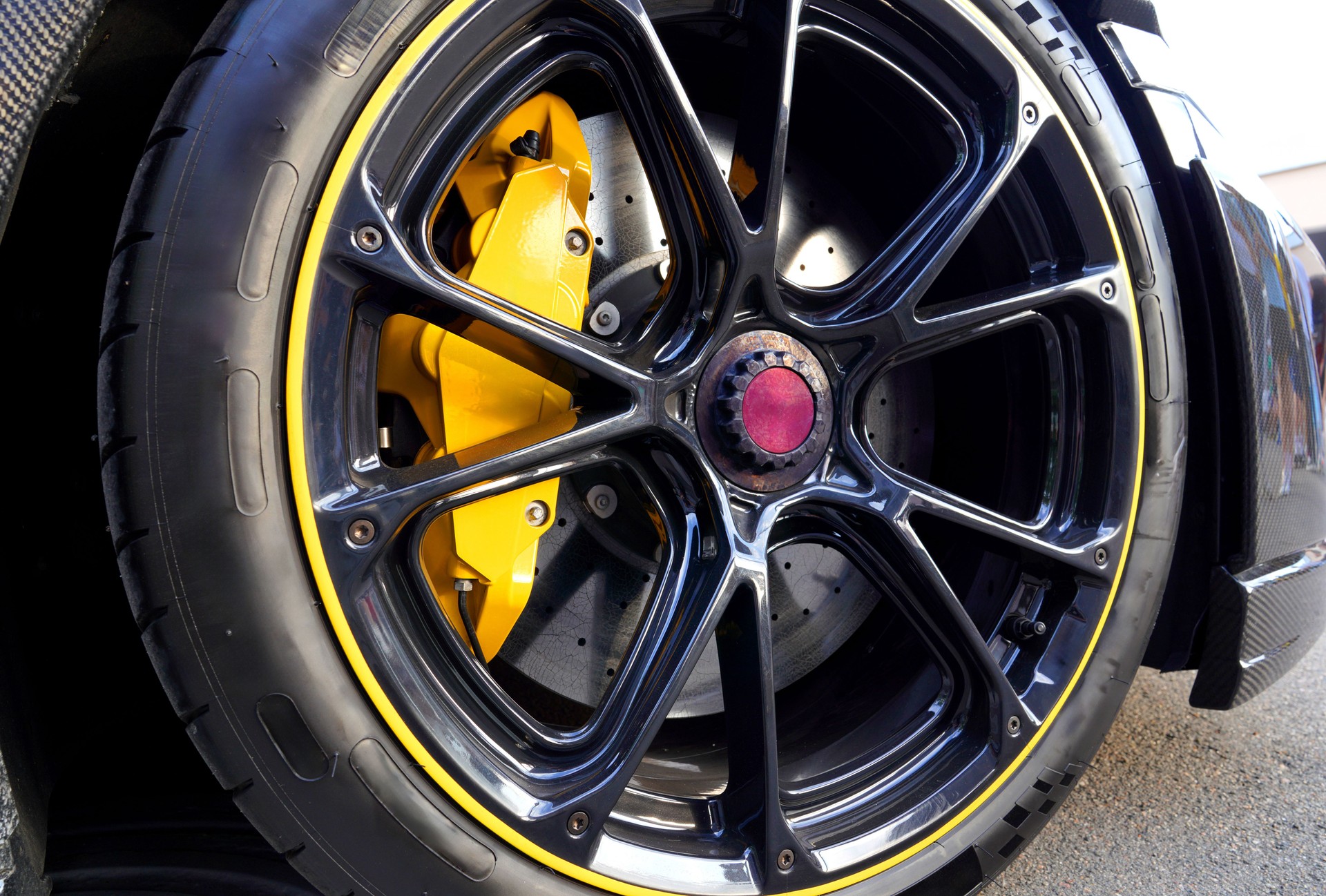Alloy wheel with calipers and racing brakes of the sport car. Racing brake disc and low profile tyres.
